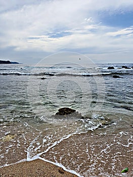 A rock in the midlle of wave photo
