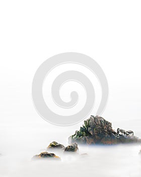 A rock among the mist of the sea and clouds