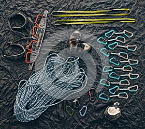 Rock or mountain climbing equipment or tools against dark background with a carabiner hook, rope for safety and security