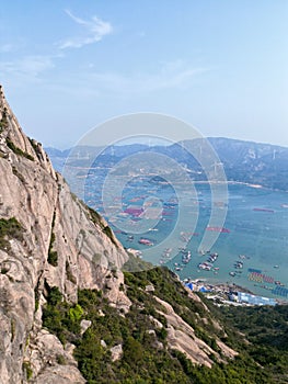 a rock mountain overlooking the ocean and a harbor in a valley