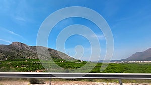 Rock mountains and olive fields view in Spain along the highway, view from the car window