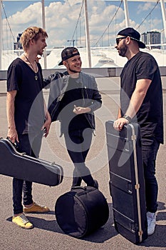 rock music band with musical instruments in cases having conversation