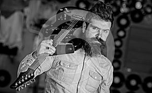 Rock musician concept. Musician with beard play electric guitar. Talented musician, soloist, singer carries guitar in photo