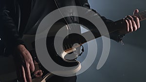 Rock musician man in smoky studio, on stage masterfully playing electric guitar