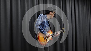 Rock N Roll guitarist playing on electric guitar. Young musician performing lyric song at home. Musical instruments concept. Male