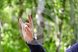 Rock `n roll hand sign. Gesture mens hand of three fingers. Concept of positive, Rock and Roll, win, devil horns. Closeup view on