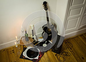 Rock'n'roll setup with ukulele, acoustic guitar, speaker, candle