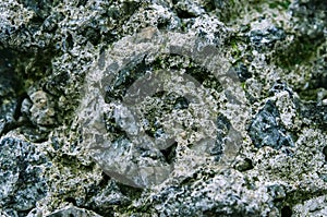 Rock. Natural background. A stone wall with a close-up of green moss