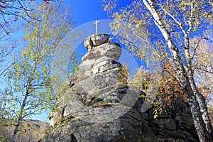 A rock with an Orthodox cross on Mount Tserkovka in the resort town of Belokurikha. Altai region. Russia