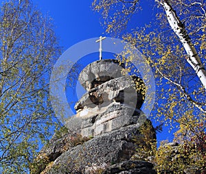 A rock with an Orthodox cross on Mount Tserkovka in the resort town of Belokurikha. Altai region. Russia