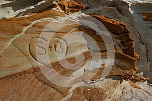 A rock outcrop with interesting patterns and colors and a heart carved into the rock