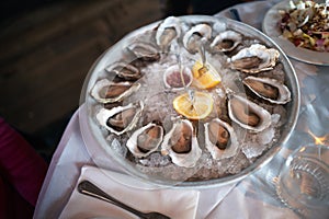 Rock Oysters prepared for sharing in a large dish, in their shell, served on ice with lemon and relish