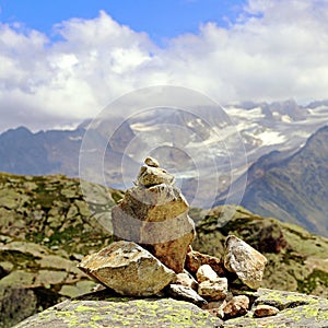 Rock pile cairn indicate the way on a mountain square format