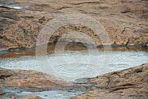 Rock pool with ripples from rain