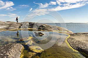 Rock pool and woman HuvudskÃ¤r Stockholm archipelago