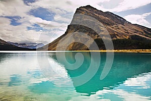 The rock is reflected in emerald lake