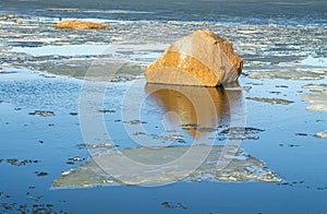 Rock reflecting in the icy spring ocean