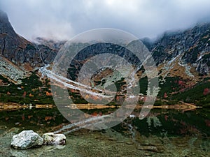 Rock and reflections in a mountain lake autumn