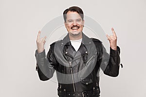 Rock and roll baby! Happines adult man toothy smiling and showing rock sign