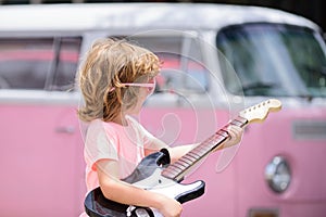 Rock and roll child. Portrait of cute boy playing a guitar. Music concept. Kids music school.