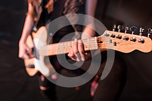 Rock and roll girl playing bass guitar on stage