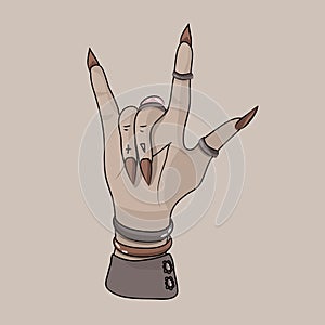 Rock and roll sign. Witch\'s hand. Gothic style. Rock festival. Decoration on the hands. Bracelets, rings.