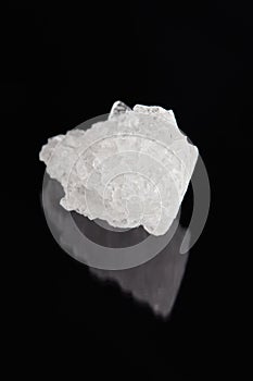 rock salt crystal over dark background. outer space. vertical orientation