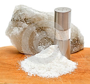 Rock salt with saltshaker and scattered salt photo