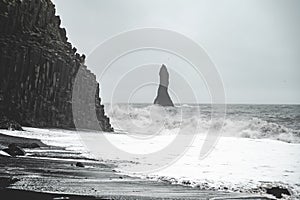 Rock sculpture with heavy waves at Black Sand Beach Reynisfjara, Iceland