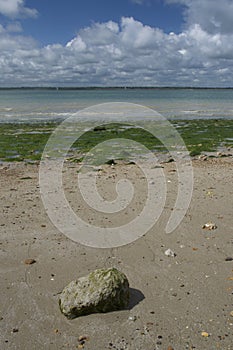 Rock on seaweedy beach overlooking Solent photo