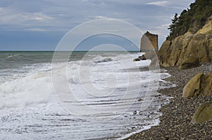 A rock in the shape of a sail on the black sea coast of Russia near the village of Praskoveyevka. Winter, storm, waves