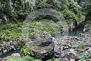 Rock, shimenawa rope, and river around Takachiho Gorge