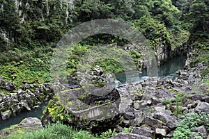 Rock, shimenawa rope, and river around Takachiho Gorge