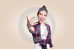 Rock sign. Happy funny toothy smiley young woman showing Rock sign with fingers. studio shot on beige background.