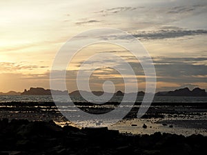 Rock silhouettes and vivid sunset while low tide