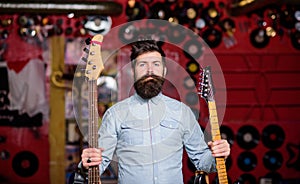 Rock singer concept. Musician with beard holds two guitars.