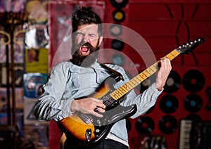 Rock singer concept. Musician with beard play electric guitar instrument.