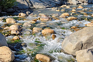 Rock stands against the force white-water rapids in the river