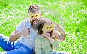 Rock star concept. Child and father posing with star shaped eyeglases photo booth attribute at meadow. Dad and daughter