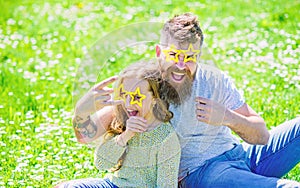 Rock star concept. Child and father posing with star shaped eyeglases photo booth attribute at meadow. Dad and daughter