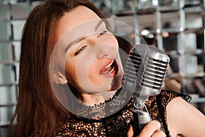 Rock star. Girl singing in retro microphone