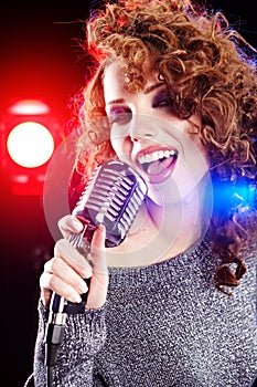 Rock star. Woman singing in retro mic
