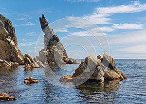 Rock sticking vertically out of the water photo