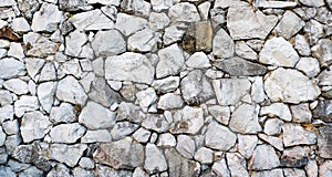 Rock stone wall background, gray color design decorative cracked real stone wall surface