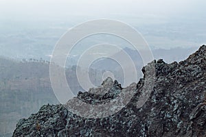 Rock surfaces and faint views beyond the fog
