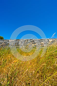 Rock wall on top of a grass incline..