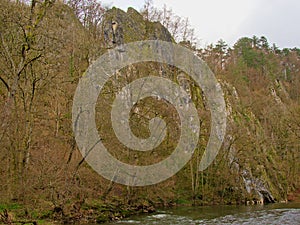 Rock wall with trees along Ourthe river, Liege, Belgium photo