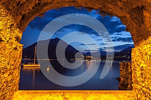 Rock window over tranquil lake Como at dusk