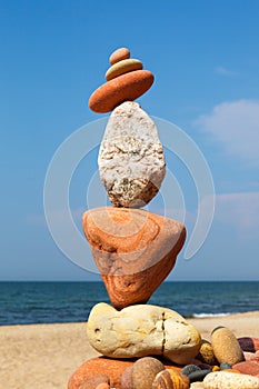 Rock zen pyramid of colorful pebbles on a background of blue sky