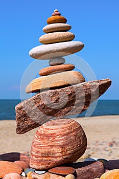 Rock zen pyramid of colorful pebbles on a background of blue sky